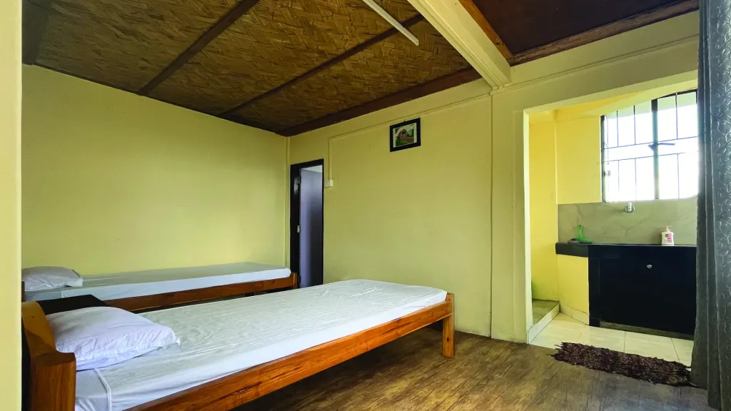 Room 2 with two beds and a doorway to the kitchen