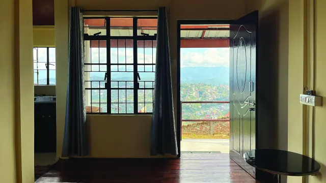 Room 1 with its door open to the personal balcony and a view over the hills