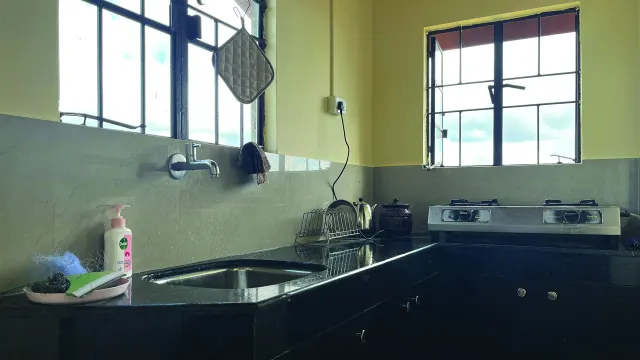 Attached kitchen of Room 1 with a gas stove and sink under the window