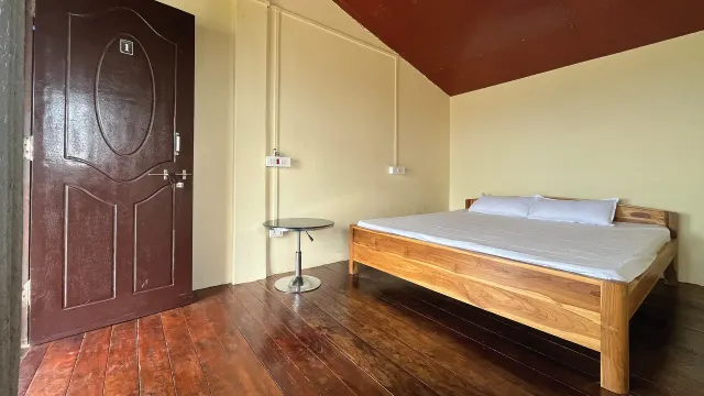 Wooden double bed in Room 1