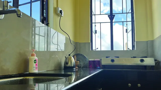 Attached kitchen of Room 2 with a stove, kettle and sink